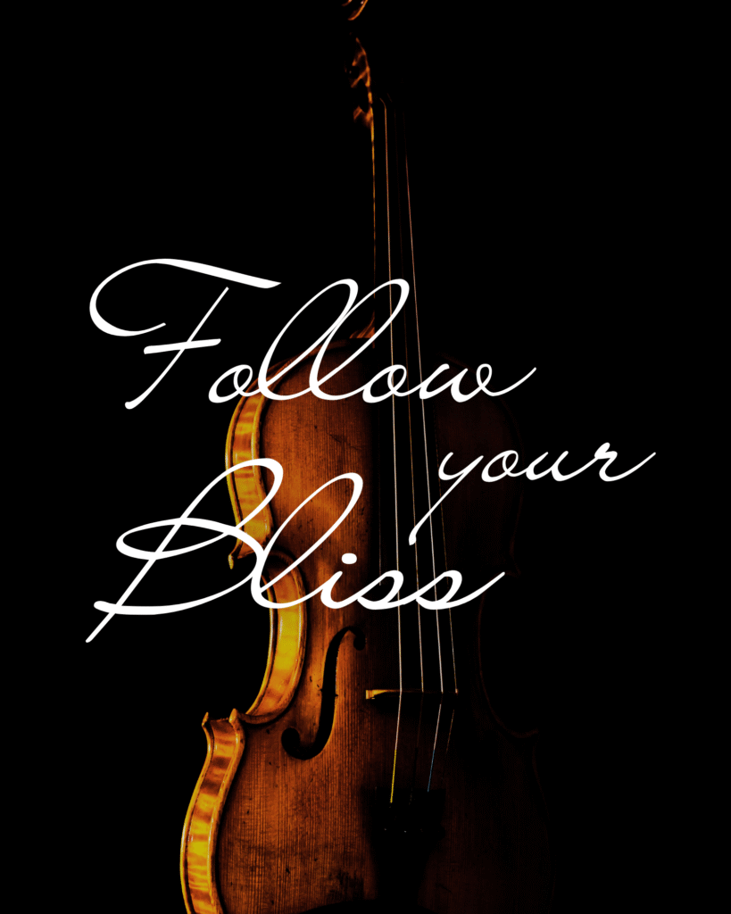 A close-up of a violin with the phrase “Follow your Bliss” written in elegant script.